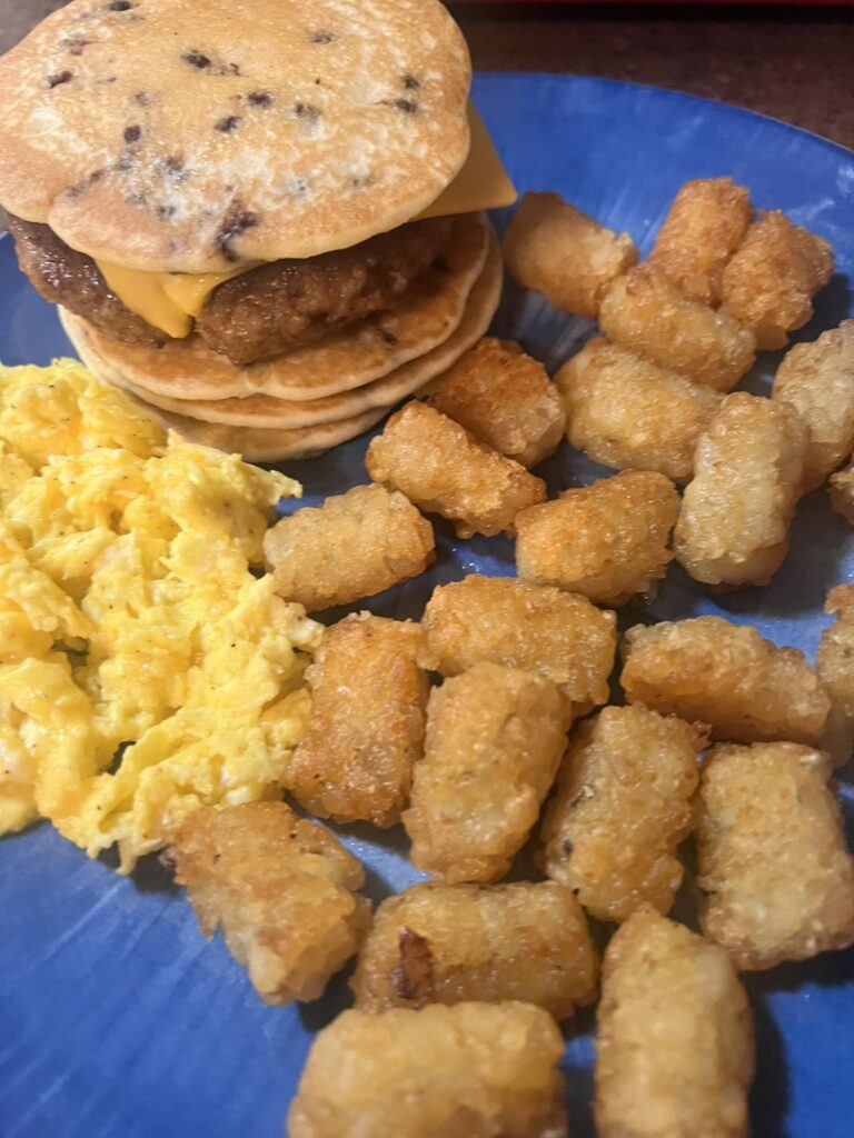 Chocolate chip pancakes sausage cheese sandwich eggs tater tots